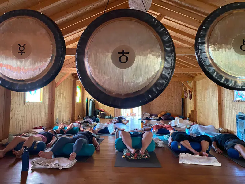 Image shows people lying down in the practice space during a gong bath on our yoga holiday October 2026